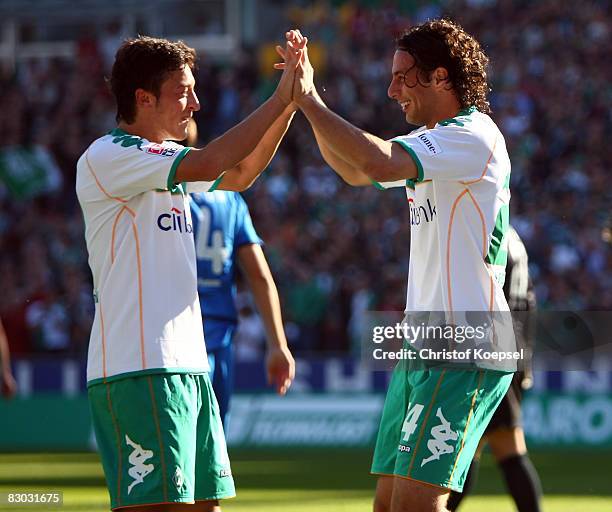 Claudio Pizarro of Bremen celebrates the second goal with Mesut Oezil during the Bundesliga match between Werder Bremen and 1899 Hoffenheim at the...