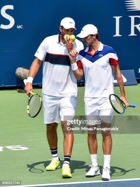 Fabrice Martin and teammate Edouard Roger-Vasselin of France talk over their strategy in their doubles match against Raven Klaasen of Russia and...