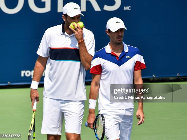 Fabrice Martin and teammate Edouard Roger-Vasselin of France talk over their strategy in their doubles match against Raven Klaasen of Russia and...