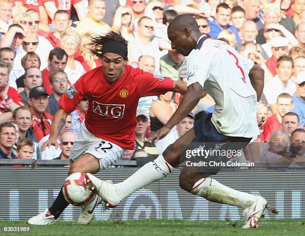 Carlos Tevez of Manchester United clashes with Jlloyd Samuel of Bolton Wanderers during the FA Premier League match between Manchester United and...