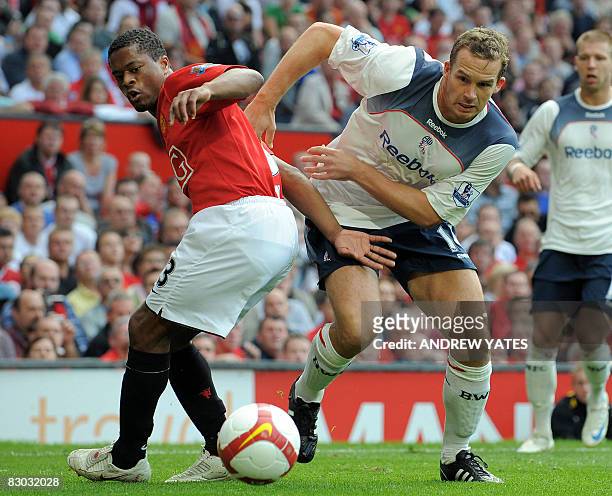 Manchester United's French defender Patrice Evra fights for the ball with Bolton Wanderers' English forward Kevin Davies during the English Premier...