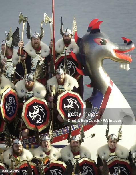 Guizers from the Jarl Squad of Shetlanders dressed as vikings salute the crowd from on top of the galley, a 30-foot wooden longship in Lerwick,...