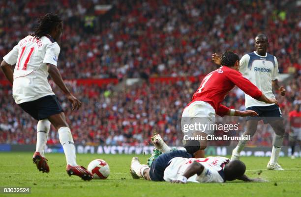 Jlloyd Samuel of Bolton Wanderers brings down Cristiano Ronaldo of Manchester United to concede a penalty kick during the Barclays Premier League...