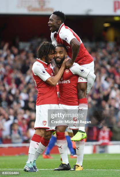 Alexandre Lacazette of Arsenal celebrates with teammates Mohamed Elneny and Danny Welbeck after scoring the opening goal during the Premier League...