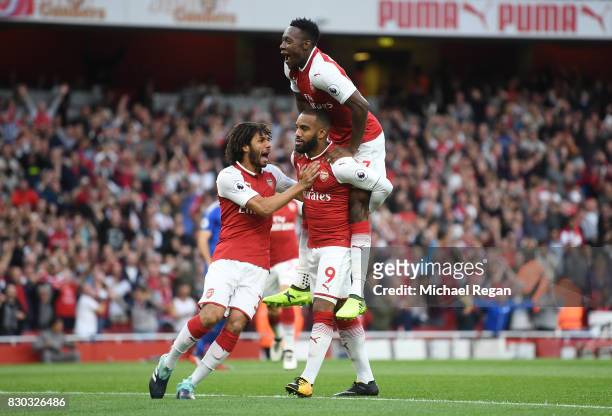 Alexandre Lacazette of Arsenal celebrates with teammates Mohamed Elneny and Danny Welbeck after scoring the opening goal during the Premier League...