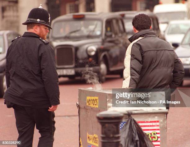 Hot dog seller is escorted away from Buckingham Palace, where he had set up his stall. New laws to stamp out unlicensed fast-food sellers at London's...