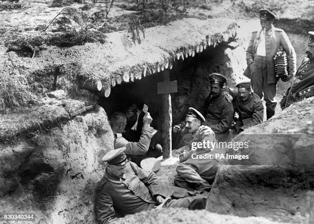 German soldiers of the 12th Regiment playing cards in a dugout in a shallow trench in German-occupied Russian Poland during the First World War. One...