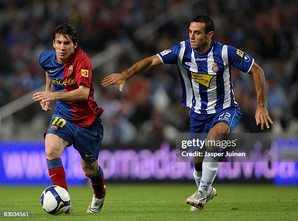 Lionel Messi of Barcelona duels for the ball with Moises Perez of Espanyol during the La Liga match between Espanyol and Barcelona at the Montjuic...