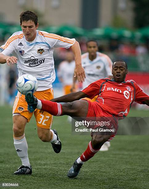 Midfielder Rohan Ricketts of Toronto FC dives for the ball with defender Bobby Boswell of the Houston Dynamo during their match on September 27, 2008...