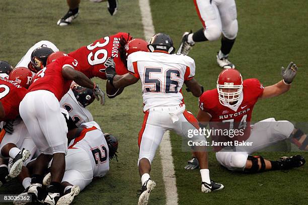 Running back Jourdan Brooks of the Rutgers Scarlet Knights falls into the end zone as line backer Gregory Onyiuke of the Morgan State Bears tries to...