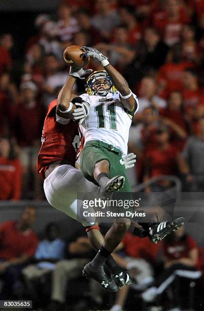 Wide receiver Marcus Edwards of the South Florida Bulls goes up high to catch a pass for a long gain as DeAndre Morgan of the North Carolina State...