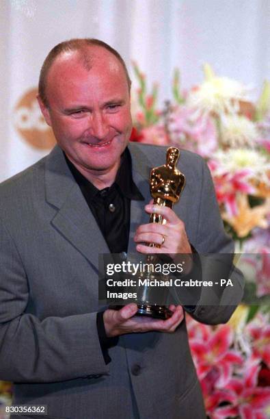 British singer songwriter, Phil Collins with his Oscar for Best Original Song which he won for the music he wrote for the Disney animated film,...