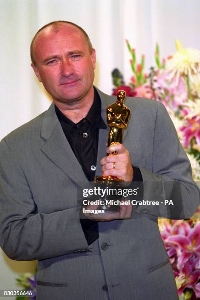 British singer songwriter Phil Collins with his Oscar for Best Original Song which he won for the music he wrote for the Disney animated film Tarzan...