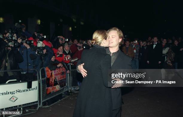 Photo 4/4/00 Kate Winslet and fiance Jim Threapleton share a kiss as they arrive for the premiere of her latest movie "Hideous Kinky" at the Odeon in...