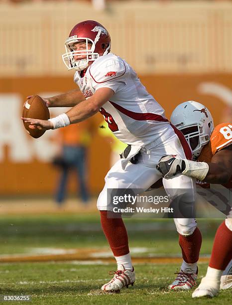 Tyler Wilson of the Arkansas Razorbacks is tackled by Sam Acho of the Texas Longhorns at Darrell K. Royal-Texas Memorial Stadium on September 27,...