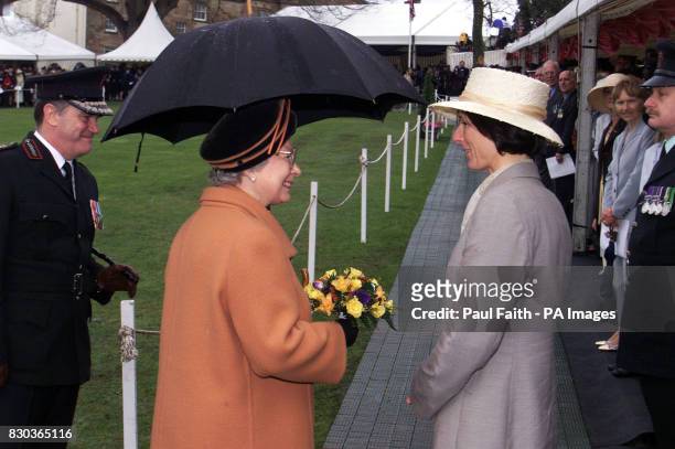 Britain's Queen Elizabeth II receives a posy of flowers from Janice O'Reilly, the wife of Constable Frankie O'Reilly the last RUC officer to be...