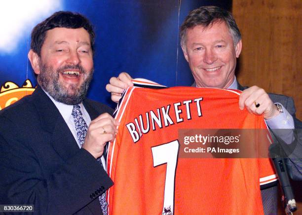 Manchester United manager Sir Alex Ferguson presents Education Secretary David Blunkett with a personalised football shirt during a visit to open the...