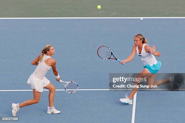 Maria Kirilenko of Russia returns a shot as doubles partner Vera Dushevina of Russia looks on during their doubles final match against Chia-Jung...