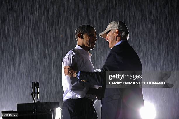 Democratic presidential candidate Illinois Senator Barack Obama and running mate Joe Bidden shake hands under rain during a rally at the University...