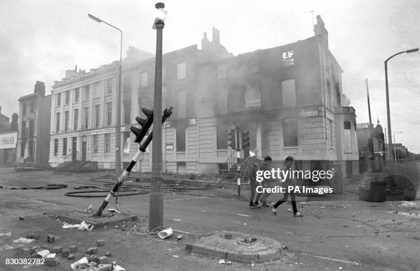 Teenagers survey the aftermath of a second night of violent rioting in the Toxteth district of Liverpool.