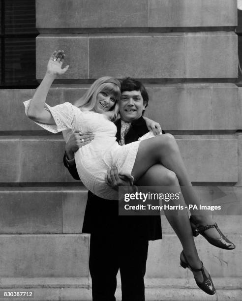 Actor Martin Shaw carries actress Jill Allen from St Pancras Town Hall following their wedding.