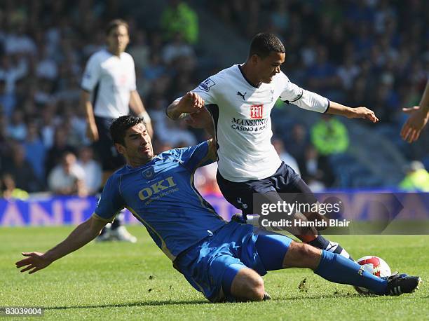 Jermaine Jenas of Tottenham Hotspur is tackled by Richard Hughes of Portsmouth during the Barclays Premier League match between Portsmouth and...