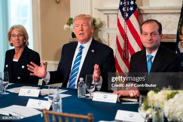 President Donald Trump speaks to the press with US Labor Secretary Alexander Acosta and US Secretary of Education Betsy Devos on August 11 at his...