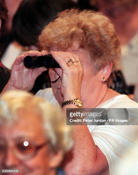 Member of the Women's Institute uses binoculars to watch the Prime Minister Tony Blair gives a speech at the Women's Institute annual conference in...