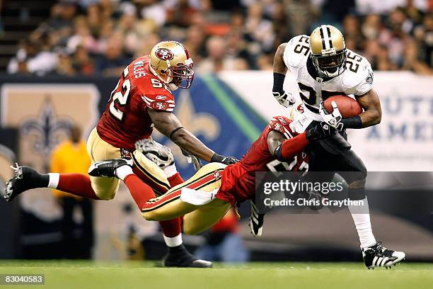 Reggie Bush of the New Orleans Saints is tackled by Walt Harris of the San Francisco 49ers on September 28, 2008 at the Superdome in New Orleans,...