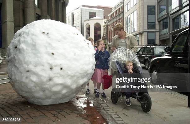 Passers by look at a snowball which is forming part of an unusual art exhibition. The thirteen one ton snowballs, made by British sculptor Andy...