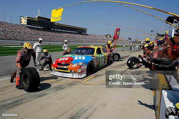 Crew members pit the M&M's Toyota, driven by Kyle Busch, during the NASCAR Sprint Cup Series Camping World RV 400 at Kansas Speedway on September 28,...