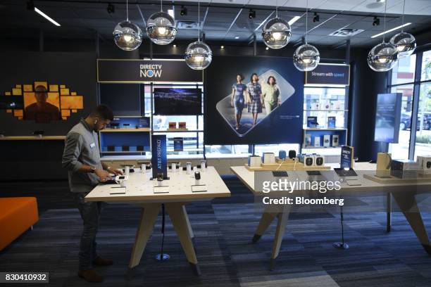 An employee uses a tablet computer at an AT&T Inc. Store in Newport Beach, California, U.S., on Thursday, Aug. 10, 2017. AT&T Inc. Shares surged the...