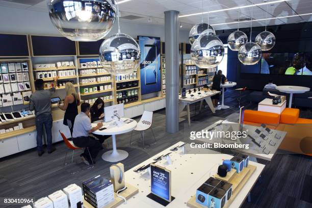 Employees assist customers at an AT&T Inc. Store in Newport Beach, California, U.S., on Thursday, Aug. 10, 2017. AT&T Inc. Shares surged the most in...