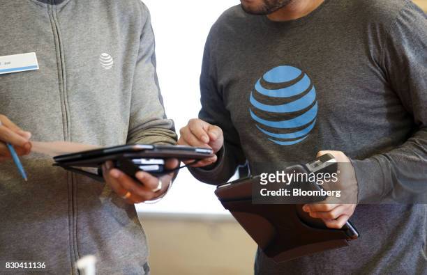 Employees use tablet computers at an AT&T Inc. Store in Newport Beach, California, U.S., on Thursday, Aug. 10, 2017. AT&T Inc. Shares surged the most...