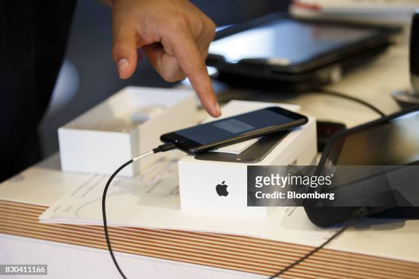 An employee activates an Apple Inc. IPhone for a customer at an AT&T Inc. Store in Newport Beach, California, U.S., on Thursday, Aug. 10, 2017. AT&T...