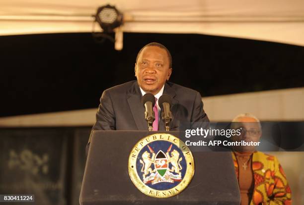 Kenya's President Uhuru Kenyatta , flanked by his wife Margaret Gakuo Kenyatta, speaks following the Electoral Commission's official announcement of...