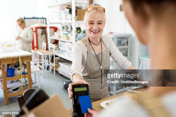 woman using contactless card to make payment - tap card stock pictures, royalty-free photos & images