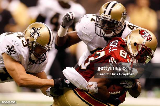 Arnaz Battle of the San Francisco 49ers is tackled by Kevin Kaesviharn and Roman Harper of the New Orleans Saints on September 28 2008 at the...