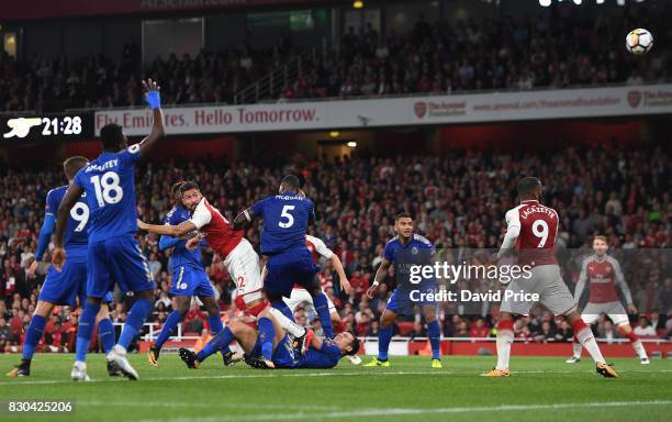 Olivier Giroud scores Arsenal's 4th goal under pressure from Wes Morgan of Leicester during the Premier League match between Arsenal and Leicester...