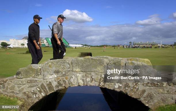 Tiger Woods and practice partner Mark O'Meara cross the bridge on the 18th at St Andrews.