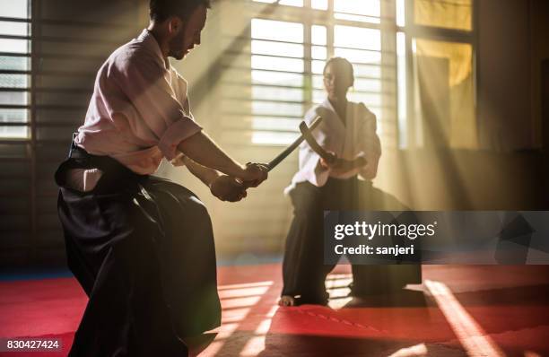 two aikido fighters with bokken swords - akido stock pictures, royalty-free photos & images