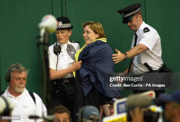 Streaker is led away by police at the end of the 18th green just as American Tiger Woods finished as overnight leader at the Open Golf Championships...