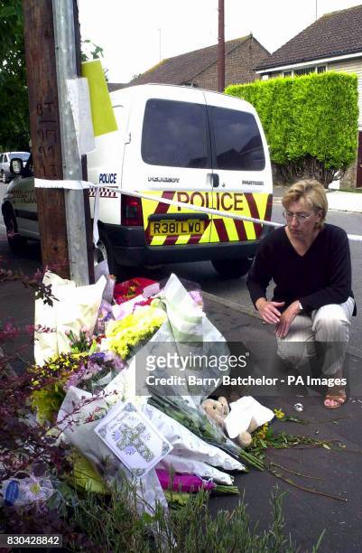 Janice Casault, a friend of Mrs Catherine Mochrie, leaves flowers outside the house in Rutland Close in Barry, South Wales, where Robert Mochrie...