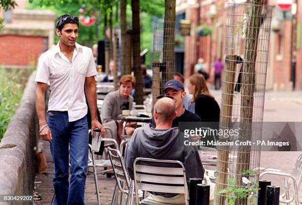 Drinkers sitting at a table outside a bar in Canal Street, Manchester, a famous gay district of the city.
