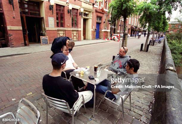 Drinkers sitting at a table outside a bar in Canal Street, Manchester, a famous gay district of the city.