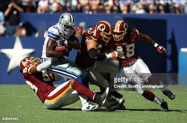 Martellus Bennett of the Dallas Cowboys is tackled by a host of Washington Redskins defenders at Texas Stadium on September 28, 2008 in Irving,...