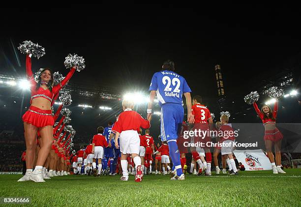 The teams of Schalke and Koeln enter the pitch during the Bundesliga match between 1. FC Koeln and FC Schalke 04 at the RheinEnergie stadium on...