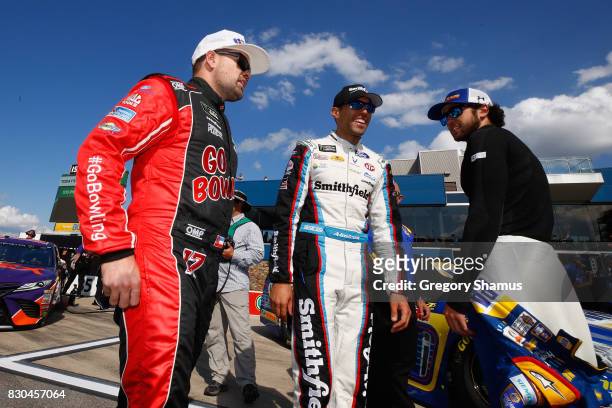 Ricky Stenhouse Jr., driver of the Go Bowling Ford, talks to Aric Almirola, driver of the Smithfield Ford, and Chase Elliott, driver of the NAPA...