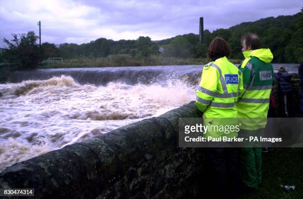 Members of the emergency services look at the weir of the River Ribble, which is downstream from Stainforth Beck, near Settle, North Yorkshire, where...