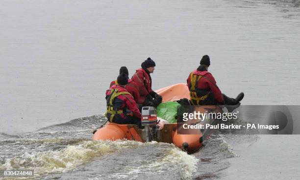 Rescue boats carries a body found during the search for two girls who were swept away while "river walking" in a swollen beck during a school trip....